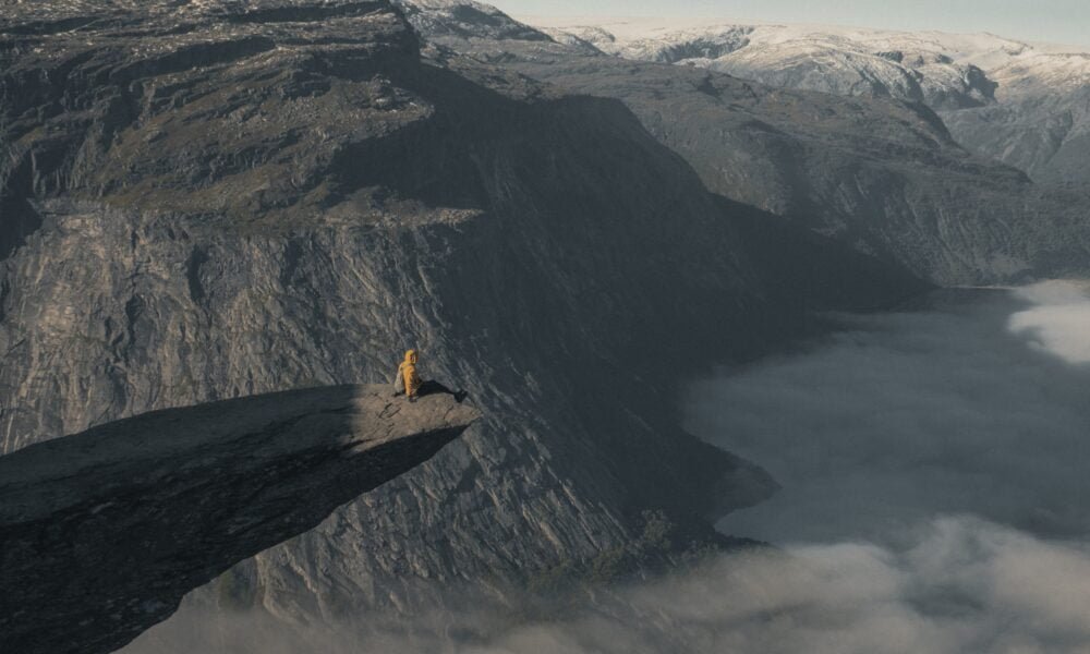 person sitting on the edge of Trolltunga