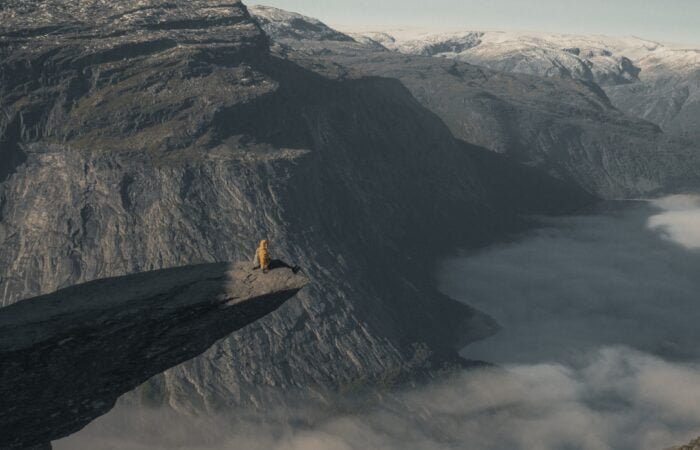 person sitting on the edge of Trolltunga