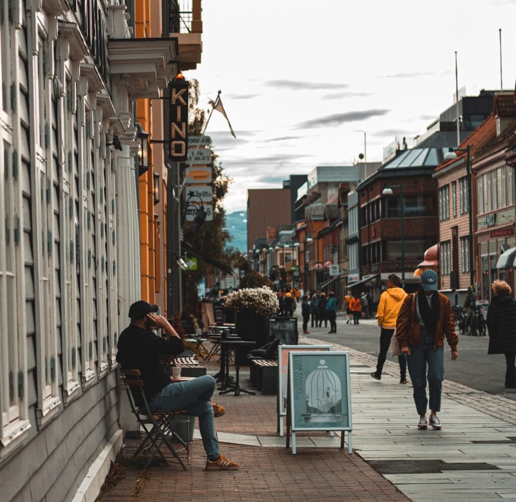 a man sitting next to a street in Tromsø, Norway